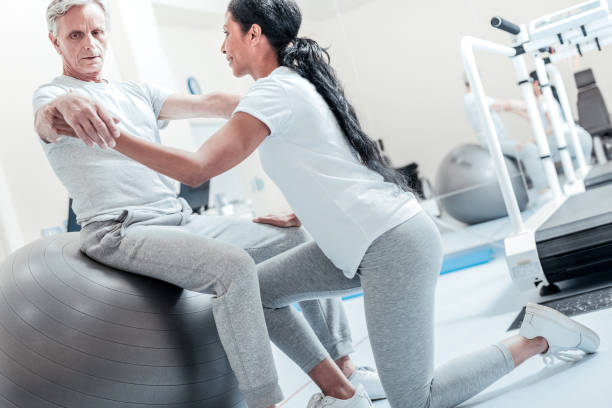 istock Cheerful woman helping old man train 921899102