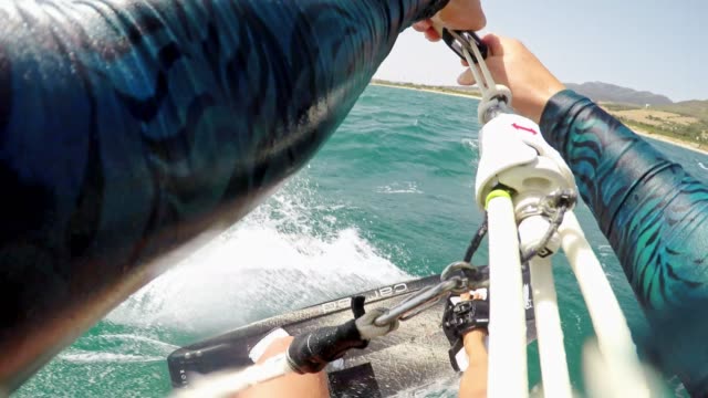 POV Female kiteboarder jumping into the air in sunshine