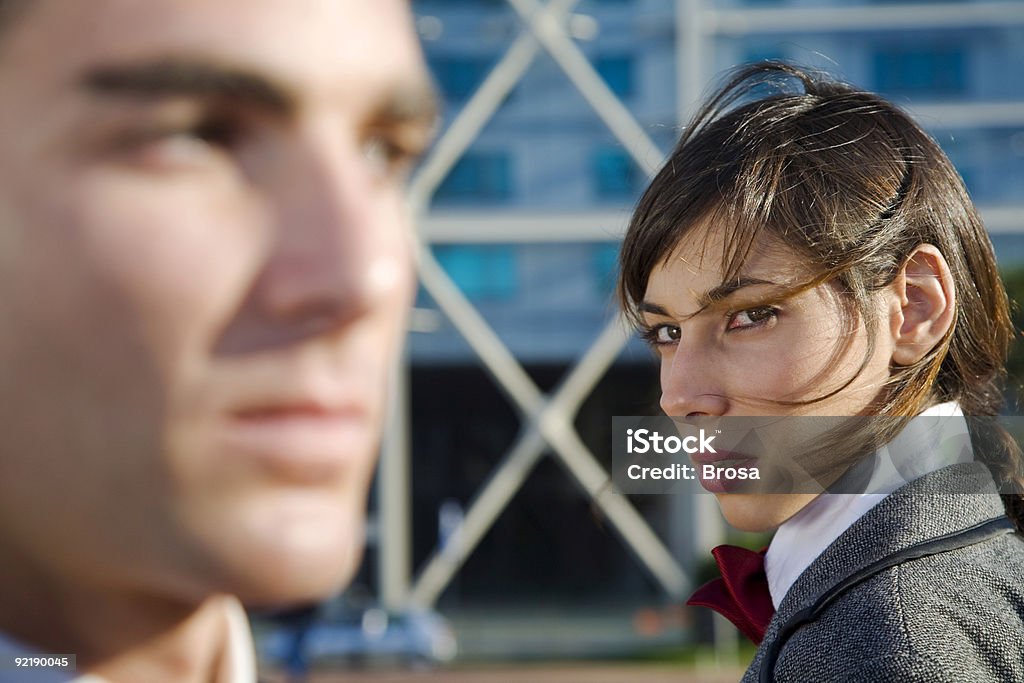 Woman looking at a man with distrust Businessman and bussinesswoman in distrust behaviour. She is in focus and he isn't. Envy Stock Photo