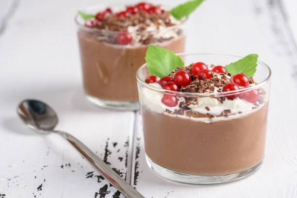 istock Chocolate mousse with currant and mint in a glasses on a white wooden background. 921902824