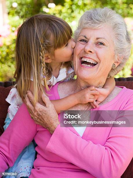 Grandmother Getting A Kiss From Granddaughter Stock Photo - Download Image Now - Kissing, Child, Girls