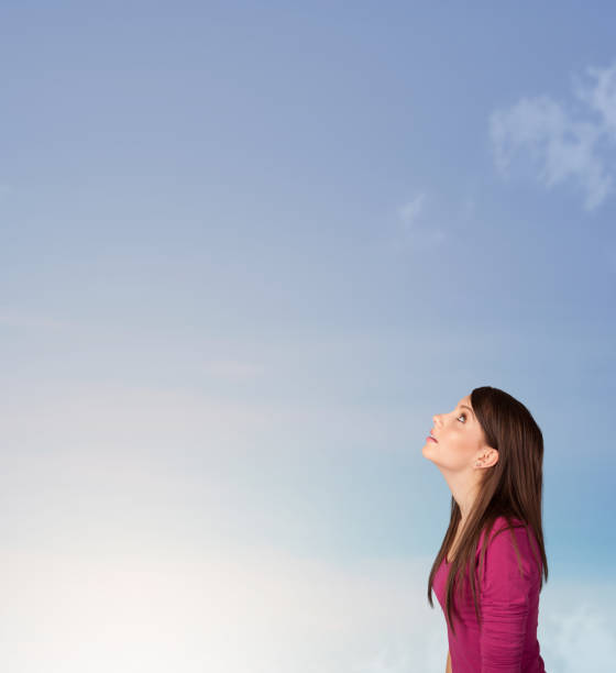 istock Girl looking at the blue sky copyspace 921903992