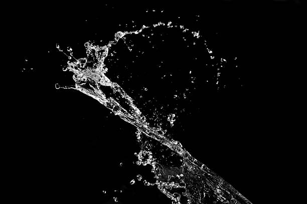 Clear water splashing against black background stock photo