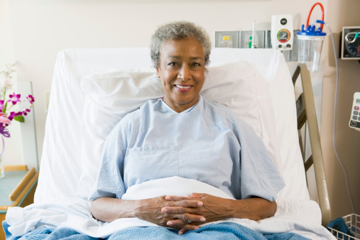 Senior Woman Sitting In Hospital Bed smiling