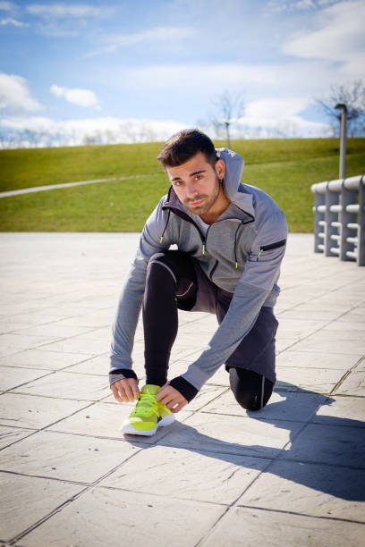 istock Young athletic man is preparing before running in a city park in winter. 921909252