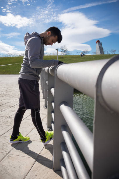 Young athletic man is preparing before running in a city park in winter. stock photo