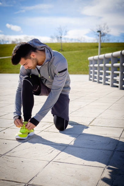 Young athletic man is preparing before running in a city park in winter. stock photo