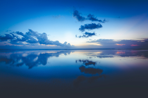 beautiful cloud reflection at seminyak beach on bali island in indonesia.
