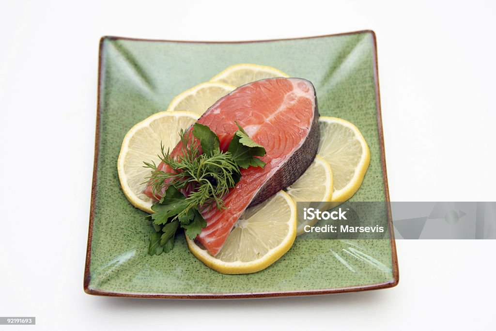 Salmone con limone e prezzemolo sul piatto - Foto stock royalty-free di Arancia