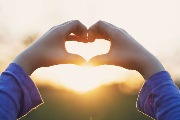 istock Hands forming a heart shape with sunset silhouette 921919400