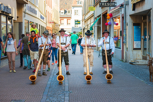 Heidelberg, Germany - September 24, 2016: Alphorn player in traditional Bavarian costumes performing on the street of Heidelberg at the fall folk festival.