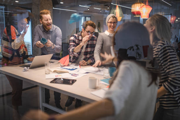 istock Group of playful entrepreneurs having fun while throwing papers in the office. 921939456
