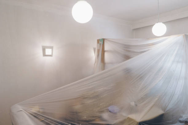 Salon est recouvert d’une feuille en plastique protectrice, préparation pour la peinture - Photo