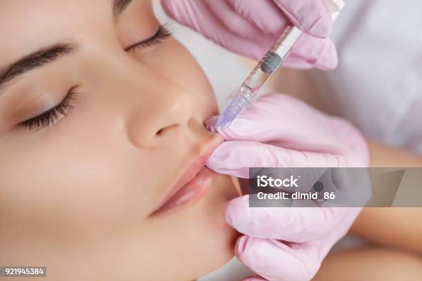 The Doctor Cosmetologist Makes Lip Augmentation Procedure Of A Beautiful Woman In A Beauty Salon Stock Photo - Download Image Now