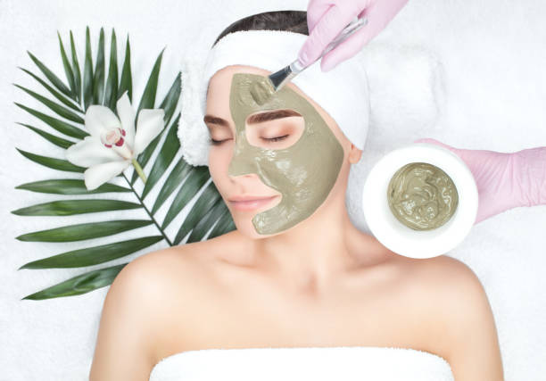 la procédure pour appliquer un masque d’argile sur le visage d’une belle femme - face mask photos et images de collection