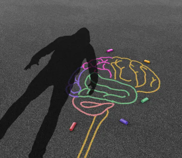 Mental illness violence and violent behavior psychology disorder as the shadow of a troubled angry person or student with chalk drawing of a human brain in a 3D illustration style.