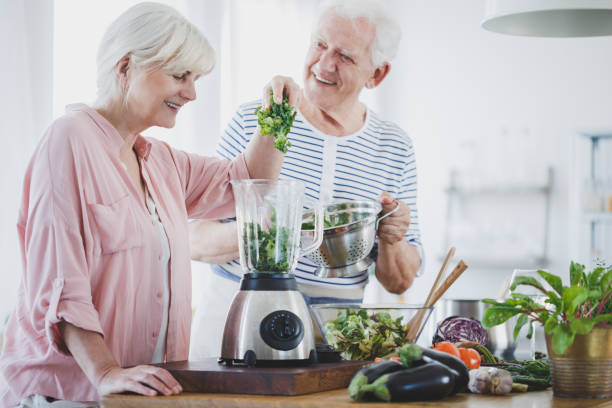 preparación batido de anciana feliz - cooking senior adult healthy lifestyle couple fotografías e imágenes de stock