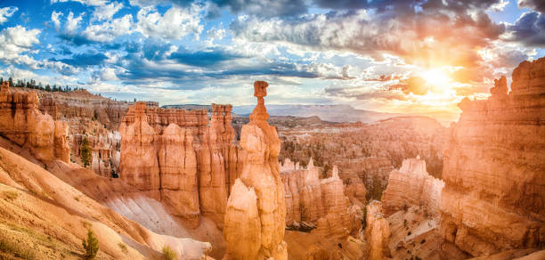 Bryce Canyon National Park at sunrise with dramatic sky, Utah, USA Panoramic view of amazing hoodoos sandstone formations in scenic Bryce Canyon National Park in beautiful golden morning light at sunrise with dramatic sky and blue sky, Utah, USA rock hoodoo stock pictures, royalty-free photos & images
