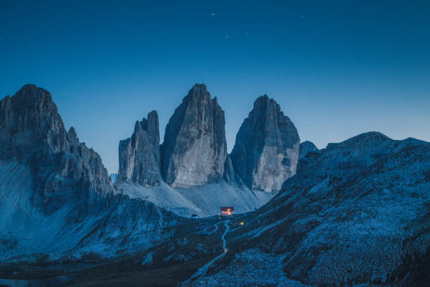 Tre Cime di Lavaredo mountain summits in the Dolomites at night, South Tyrol, Italy Beautiful view of famous Tre Cime di Lavaredo mountains in the Dolomites mountain range with famous Rifugio Antonio Locatelli alpine hut on a clear starry night in summer, South Tyrol, Italy dolomite photos stock pictures, royalty-free photos & images