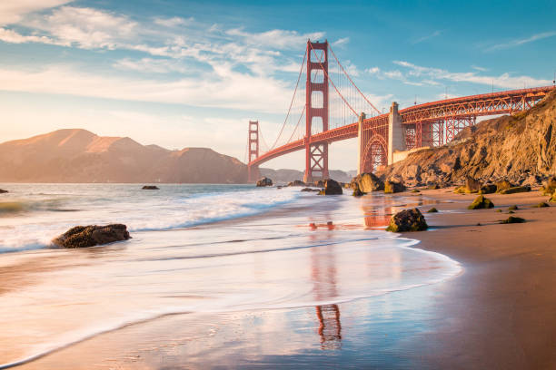 Golden Gate Bridge at sunset, San Francisco, California, USA Classic panoramic view of famous Golden Gate Bridge seen from scenic Baker Beach in beautiful golden evening light on a sunny day with blue sky and clouds in summer, San Francisco, California, USA baker beach stock pictures, royalty-free photos & images