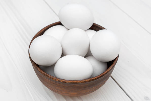 istock Bowl with eggs on the white wooden table. 921972826