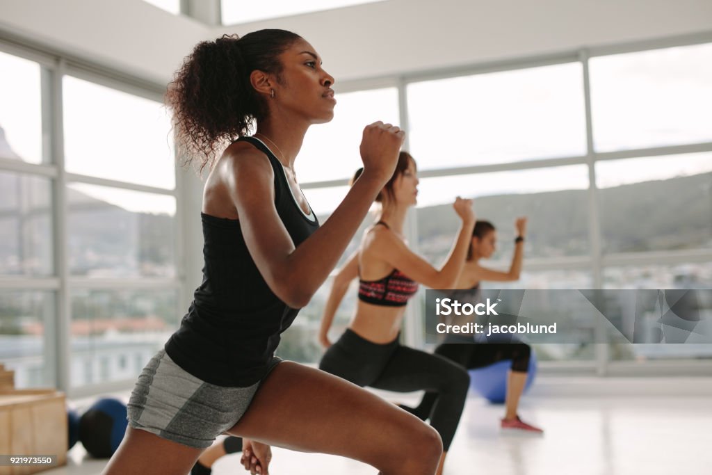 Females working out together in the health studio Young woman in sportswear doing exercise during intensive circuit training in gym class. Females working out together in the health studio. Effort Stock Photo