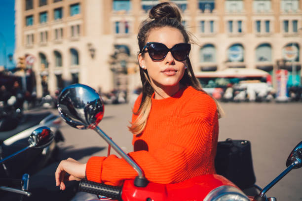 Young woman in Spain leaning on scooter and looking at view