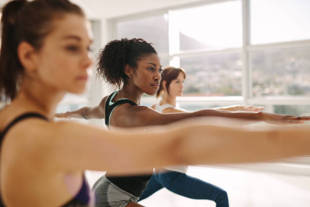 istock Woman doing the warrior pose during yoga class. 921976252