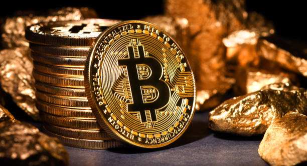 Bitcoin mining İstanbul, Turkey - February 19, 2018: Close up shot of gold nuggets and bitcoin memorial coins on a desk. Bitcoin is a crypto currency and a worldwide payment system. gold bitcoin stock pictures, royalty-free photos & images