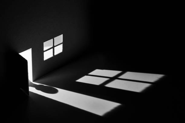 Toy house with light falling through door and window to make a creepy shadow