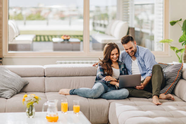istock Happy couple using laptop on sofa in the living room. 921991266