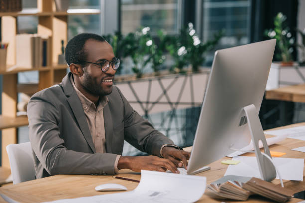istock african american architect working with computer and blueprints in office 921997224