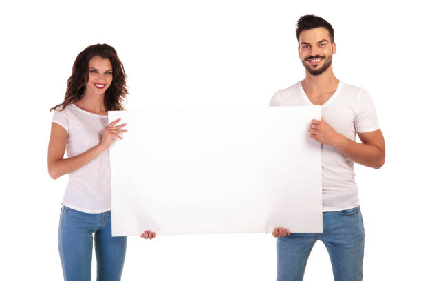 istock happy young casual couple presenting big blank board 922001982