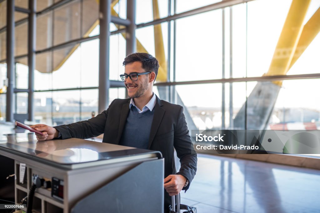 attractive young man check-in at the airport with his passport Airport Stock Photo