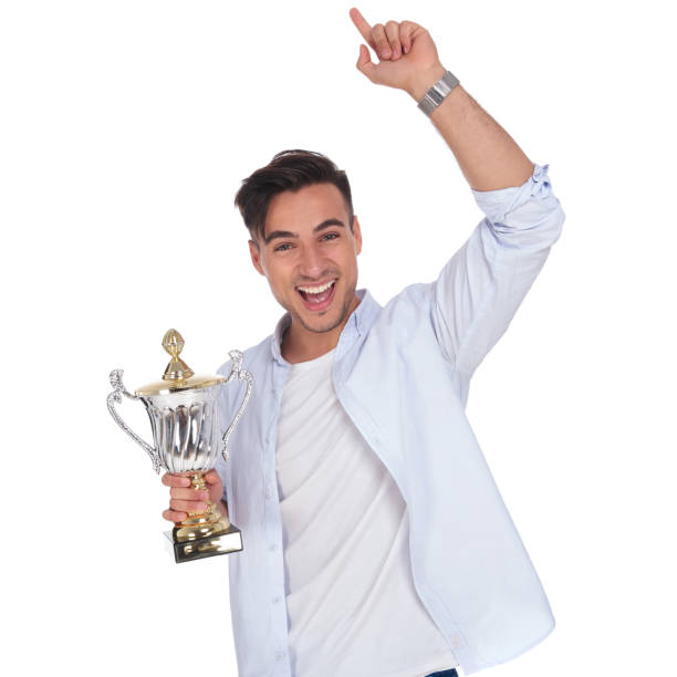 istock excited young casual man holding trophy cup is celebrating 922007972