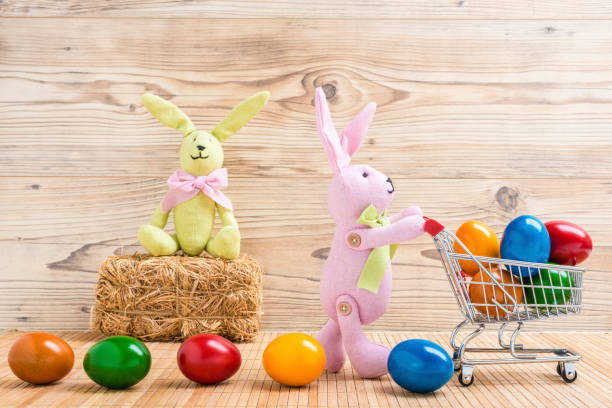 istock Two Easter bunnies with a shopping cart and many colorful Easter eggs 922008188