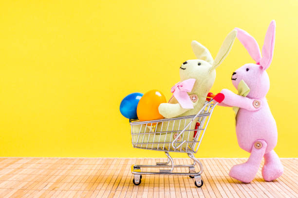 istock Two Easter bunnies with shopping cart and Easter eggs 922010374