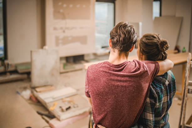 widok z tyłu ogarniętej pary w ich mieszkaniu remontowym. - home remodeling zdjęcia i obrazy z banku zdjęć