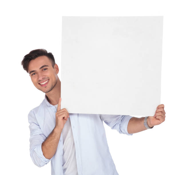 istock smiling casual man holding blank ad at his side 922010934