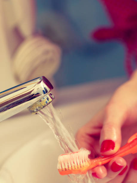 istock Woman cleaning her toothbrush 922012192