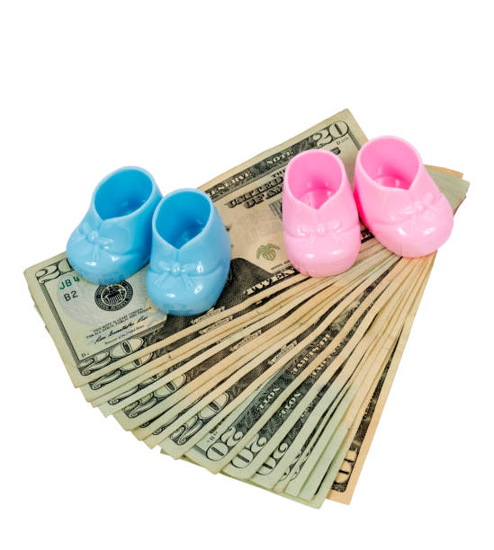 pink and blue plastic booties sitting on fanned out twenty dollar bills with a ten at the bottom - twenty dollar bill us currency currency fanned out imagens e fotografias de stock