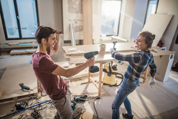 istock Young joyful couple playing with drill while making home improvements in their apartment. 922017942