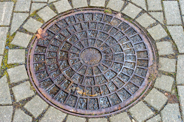 round manhole cover on the footpath - rusty city life metal rust imagens e fotografias de stock