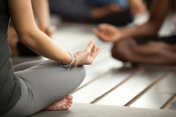 Photo of Young sporty woman in Sukhasana exercise, close up