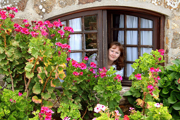 Detail of cast iron balcony, stone arch and bushes full of roses. Cambados, Galicia, Spain.