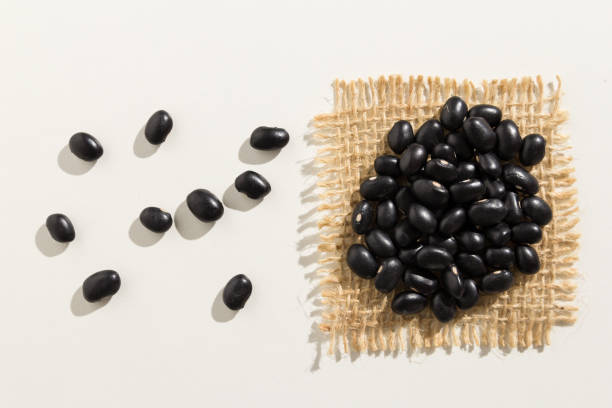istock Black Turtle Bean legume. Close up of grains spreaded over white table. 922032116