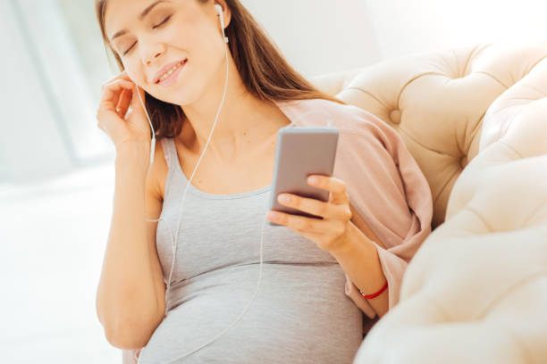 istock Cute pleasant woman lying and listening to musing 922032128