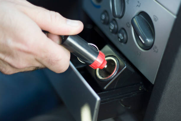 istock Hand inserts the plug into the 12V socket from the car's cigarette lighter. 922053486