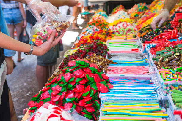 istock Customers choose sweets from counter with assorted colorful different shape jelly candies on market place in Tel Aviv, Israel. Selective focus, space for text. 922053492