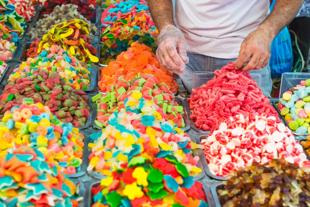 istock Seller unfolds sweets on counter with assorted colorful different shape jelly candies on market place in Tel Aviv, Israel. Selective focus, space for text. 922053540